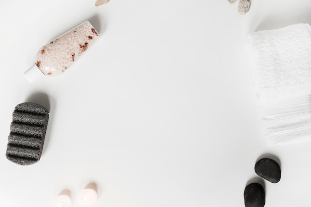 Free photo pumice stone; herbal salt; spa stone; candles and towel on white background