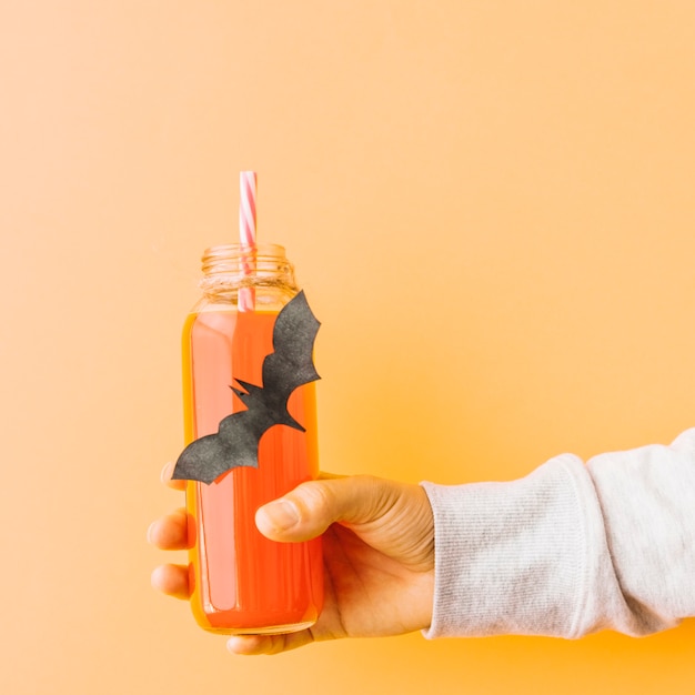 Free photo pumpkin drink in bottle with bat application