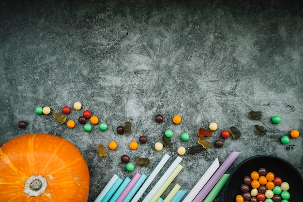 Pumpkin near straws and sweets