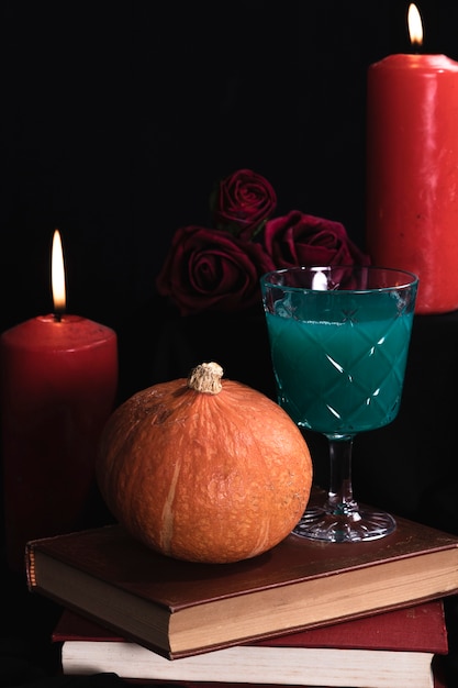 Pumpkin with green drink and books