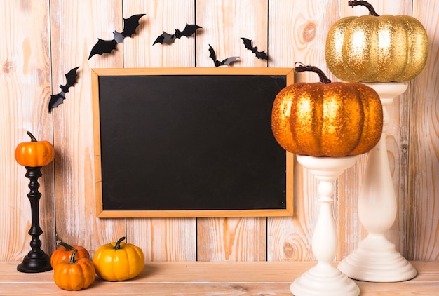 Free photo pumpkins near bats and chalkboard