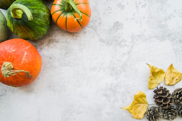 Free Photo pumpkins on table with yellow leaflets