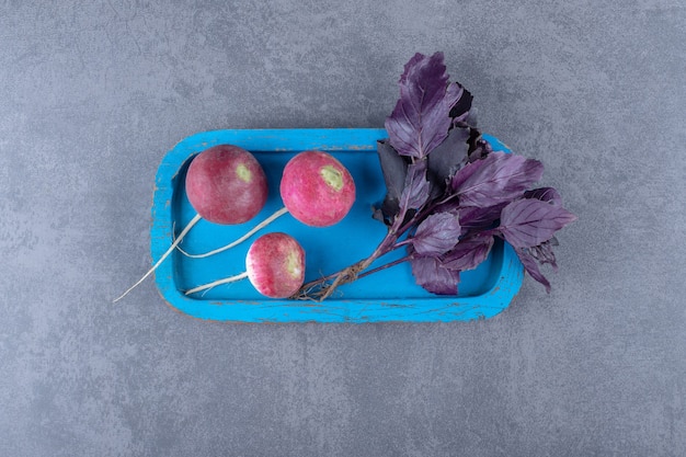 Free photo purple basil with radishes on the board , on the marble surface.