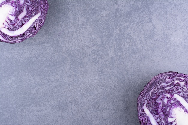 Purple cabbage cut into half on a concrete background.