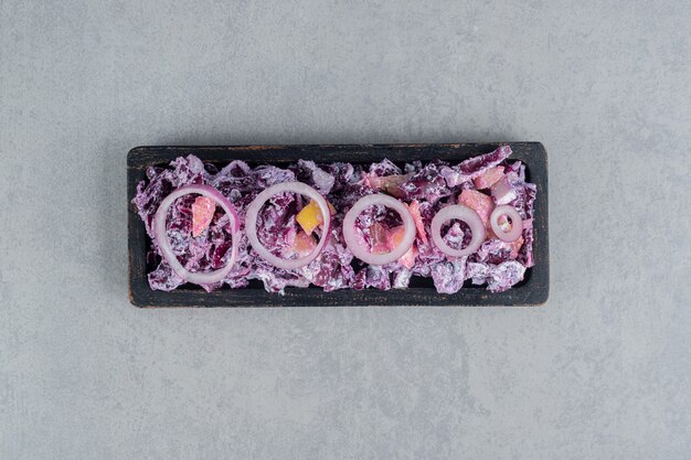 Purple cabbage and onion salad with various ingredients on a platter.