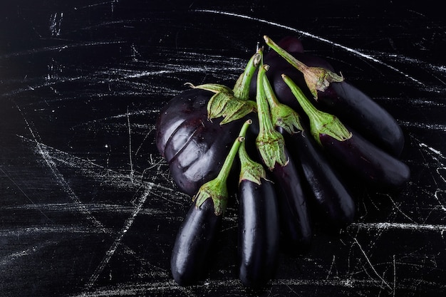 Free photo purple eggplants on black