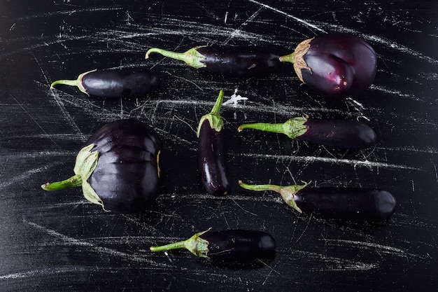 Free photo purple eggplants on black