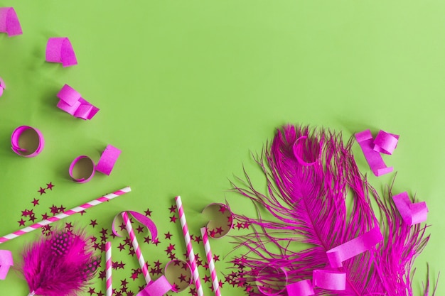 Purple feather with confetti on a green table