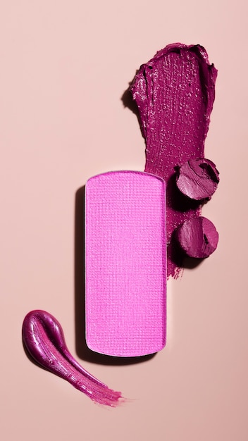 Purple lipstick shade on pink background flat lay