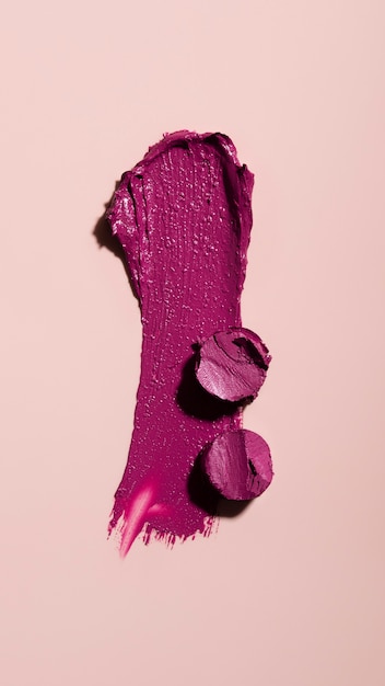 Purple lipstick shade on pink background above view