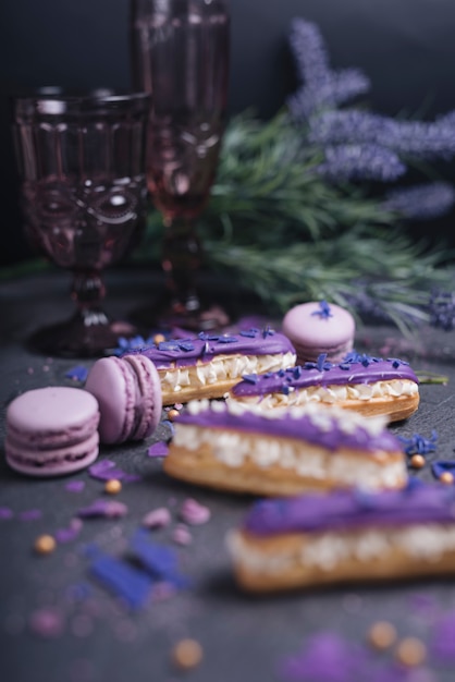 Free photo purple macaroons falling from the decorative glass on dark textured background