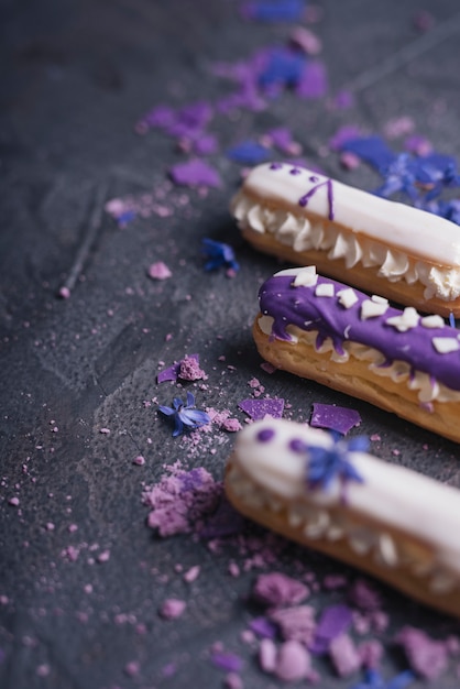 Free Photo purple macaroons with lavender flowers on dark black background