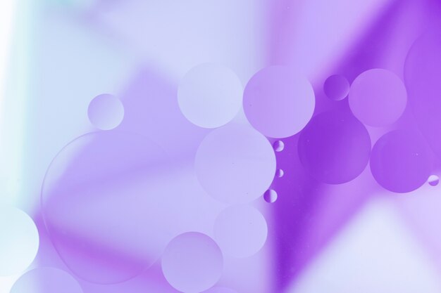 Purple oil drops on pale color surface