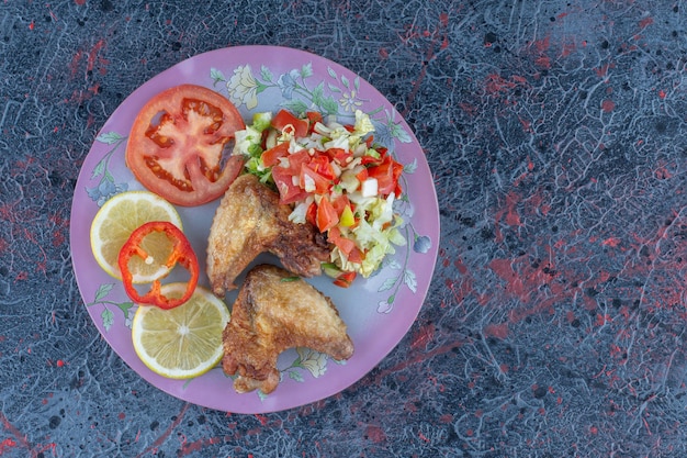 A purple plate of chicken meat with vegetable salad . 