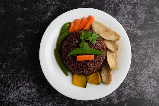 Purple rice berries cooked with grilled chicken breast. Pumpkin, carrots, and mint leaves in a dish, clean food.