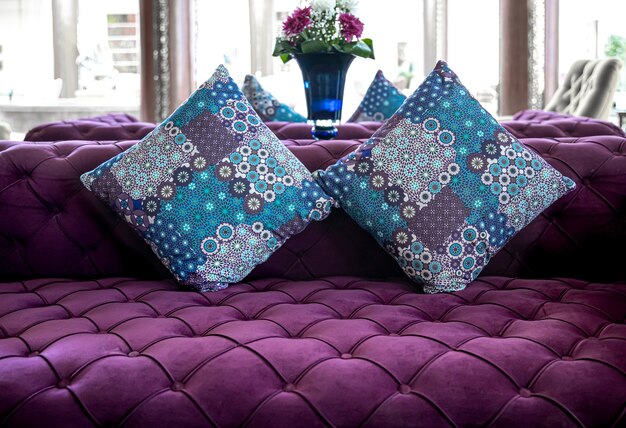 Free Photo purple velvet fabric modern sofa with sunken buttons and colorful decorative pillows. idea and variant of fabric for upholstery sofa.