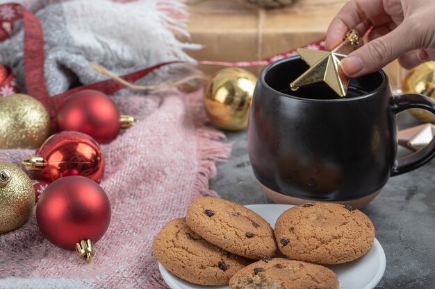 Putting a golden cristmas star into a drink cup