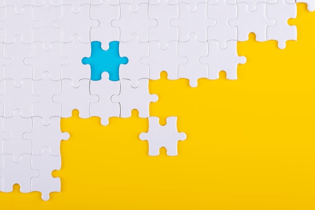 Free photo puzzle pieces with yellow and blue background