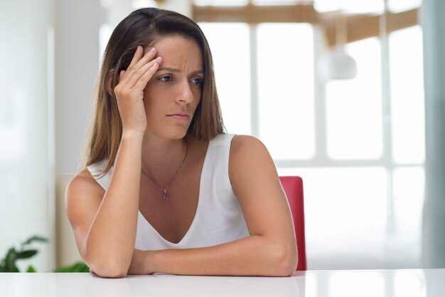 Puzzled young woman suffering from headache