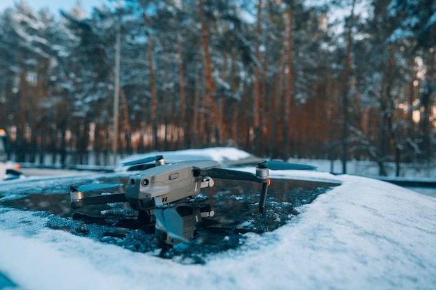 Quadrocopter standing on the roof of a snow-covered car