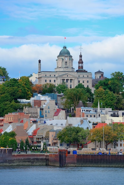 Quebec City skyline over river with blue sky and cloud.