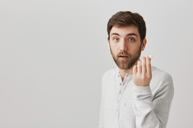 Questioned guy take-off earbud to hear