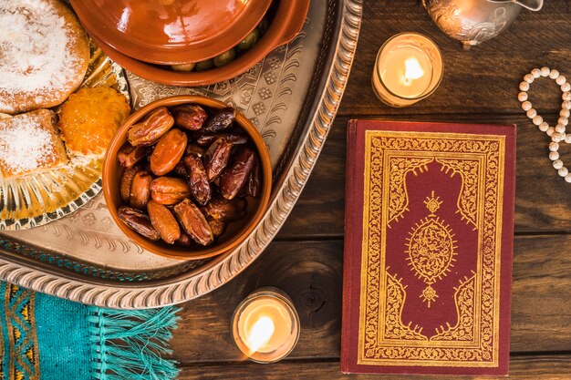 Quran and candles near Arabic food