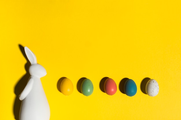 Free photo rabbit figurine with easter eggs on table