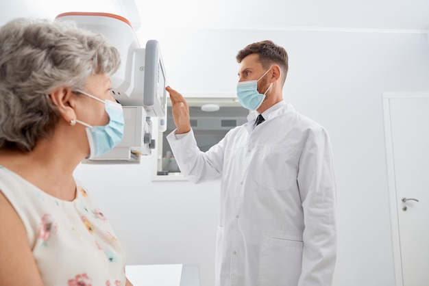 Radiologist touching screen of modern equipment starting scanning