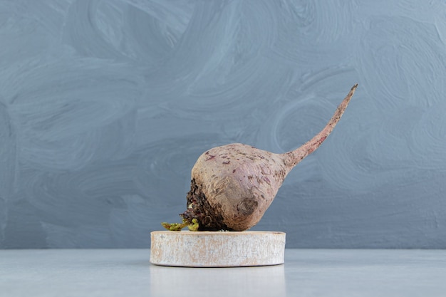 Free photo radish on the wooden trivet , on the marble.