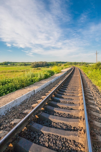 Railway station against beautiful sky at sunset Industrial landscape with railroad colorful cloudy blue sky