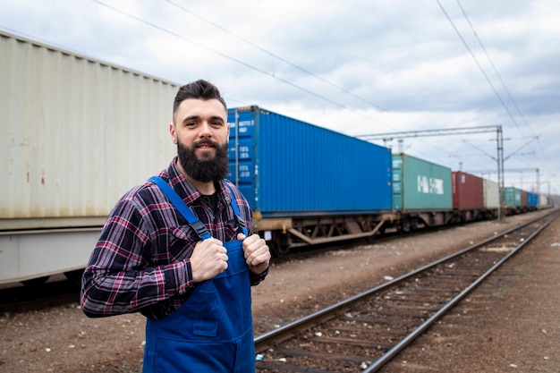 Railway worker proudly standing at train station