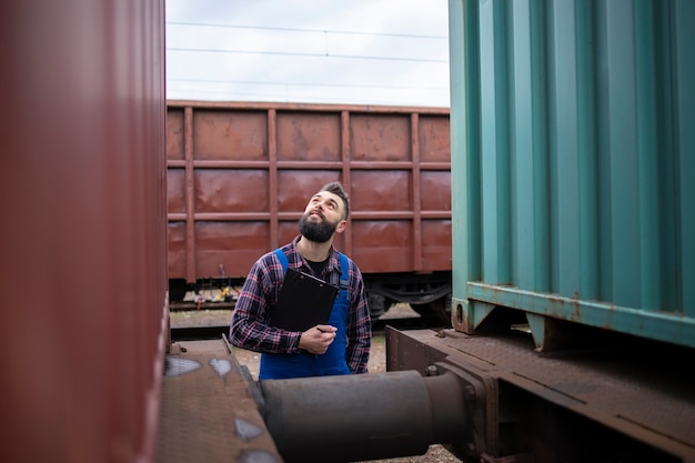 Free Photo railwayman checking train trailers before departure