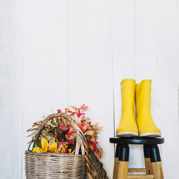 Free photo rain boots near baskets with dry leaves