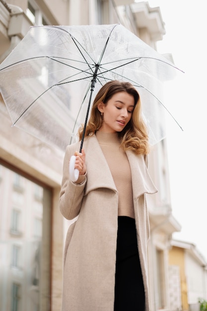 Rain portrait of young beautiful woman with umbrella