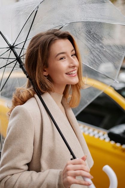 Rain portrait of young beautiful woman with umbrella