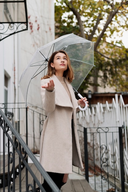 Free Photo rain portrait of young beautiful woman with umbrella