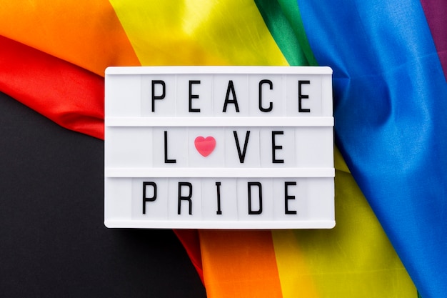 Free Photo rainbow pride flag and "peace love pride" quote close-up