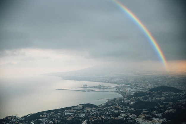 Free photo rainbow in the sky with view of the city