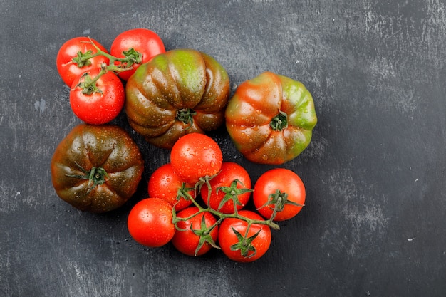 Rainy tomatoes on a grungy grey wall. top view.