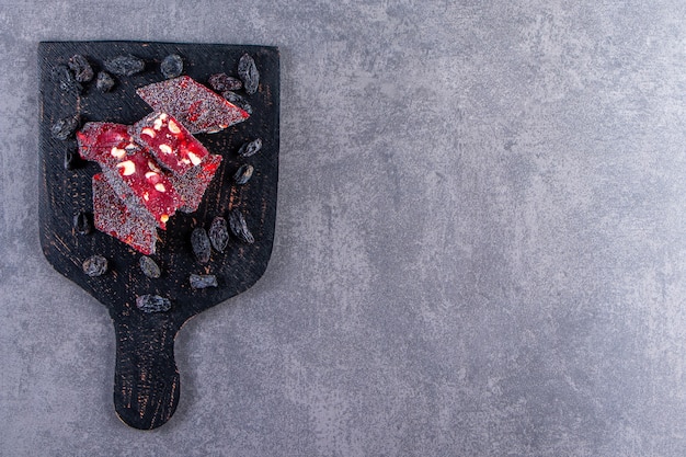 Free Photo raisins and turkish delights in a cutting, on the marble background.