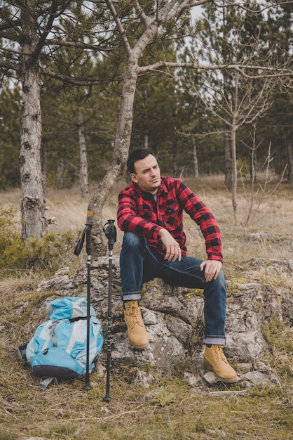 Rambler with backpack and walking sticks resting