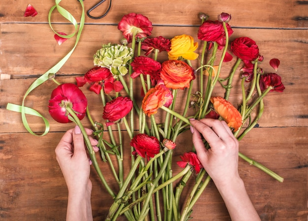 Free Photo ranunkulyus bouquet of red flowers on wooden