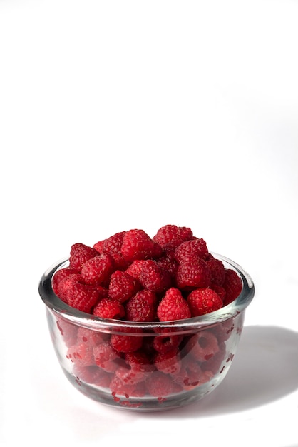 Raspberries in a glass bowl isolated