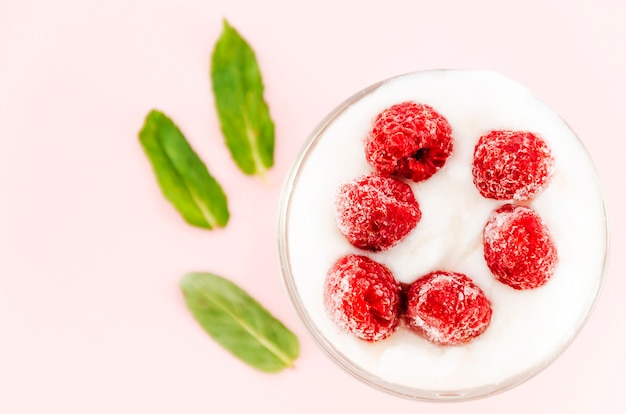 Free Photo raspberries with cream and green leaves 