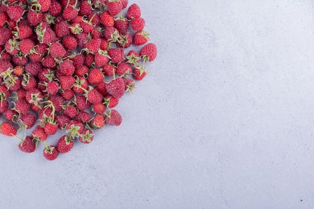 Raspberry heap scattered on marble background. High quality photo