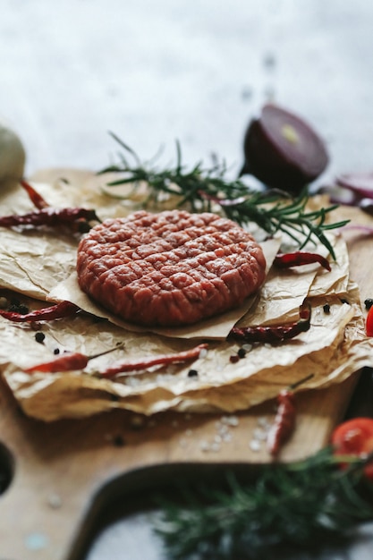 Free photo raw beef hamburger patties with herbs and spices