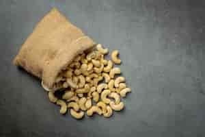 Free photo raw cashews nuts in bag on dark background