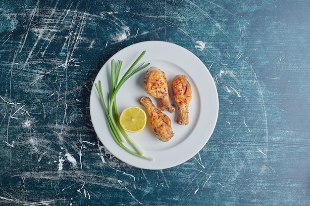 Free Photo raw chicken legs with greenery and lemon.