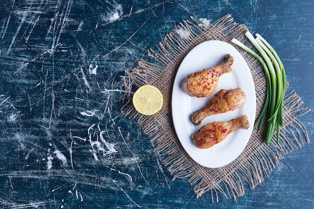 Free photo raw chicken legs with greenery and lemon.